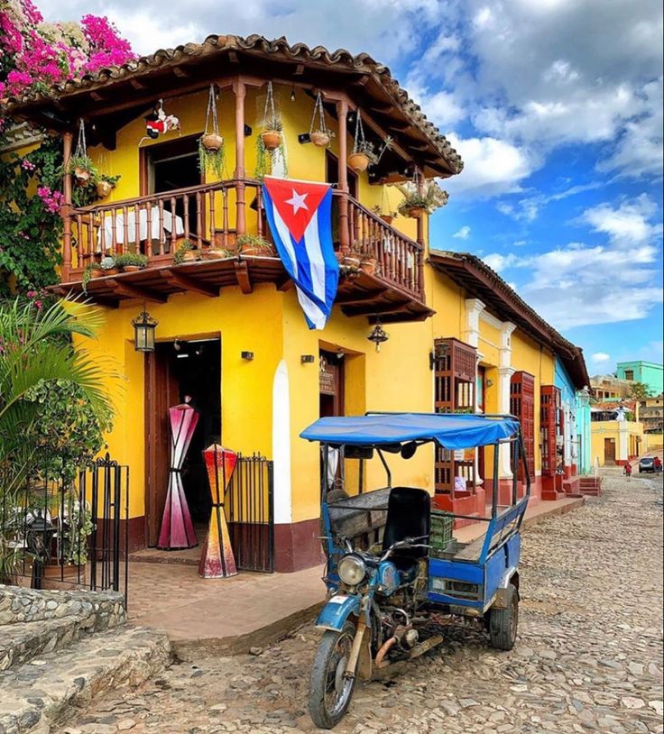 Calle colorida de Cuba con un cocotaxi